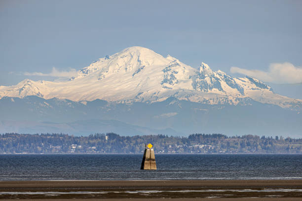 Looking across Boundary Bay from Centennial Beach, with an international boundary marker and Mount Baker in Washington State in the distance.