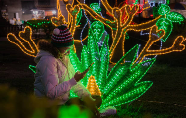 istock young woman sitting at christmas time using her mobile phone 2164807441