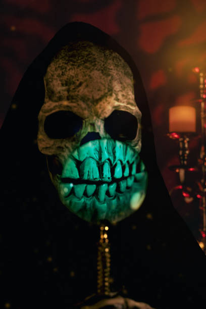 A skeletal figure resembling the Grim Reaper, holding a magnifying glass.