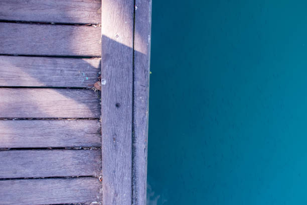 Wooden deck and blue lake with fish Texture background