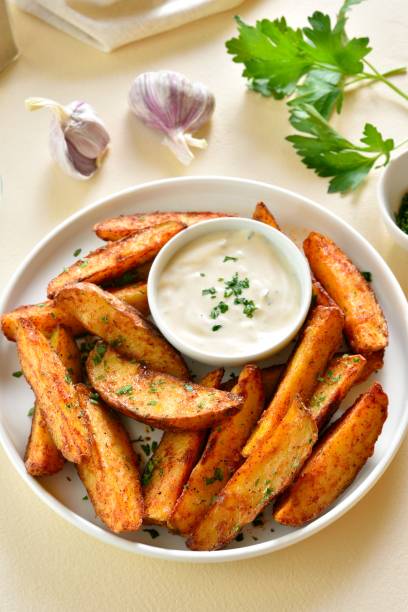 istock Oven baked potato wedges with sauce 2164816265