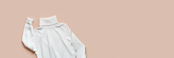 istock White knitted turtleneck or sweater, elegant garment, comfort and style basic clothes. Soft pullover snow-white hue on beige cream trend color background, banner, copy space, minimal fashion 2164817984