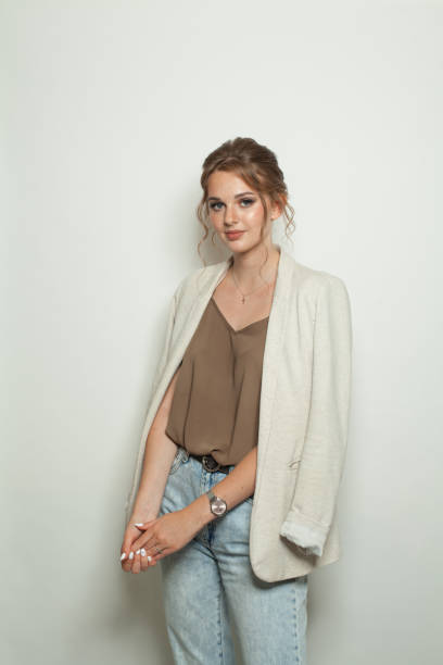 istock Cheerful casual model woman wearing light jacket standing against white studio wall background 2164818210