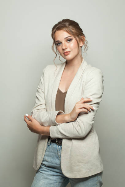 istock Successful casual model woman wearing light jacket standing against white studio wall background 2164818222