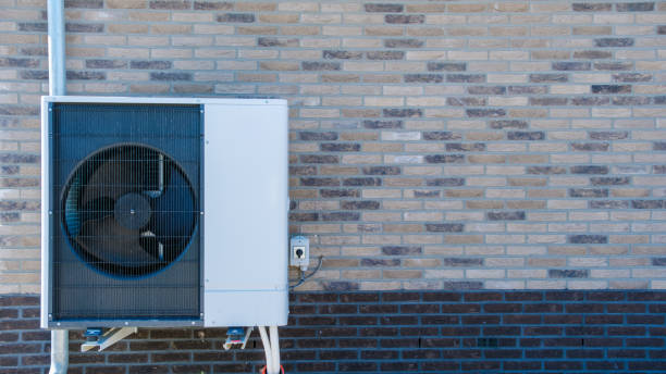 Air Source Heat Pump Installed on Exterior Wall During Sunny Day A modern air source heat pump is mounted on a brick wall, efficiently providing heating and cooling, harnessing outdoor air for comfort. warmte pomp translation air source heat pump wall mounted air conditioner stock pictures, royalty-free photos & images