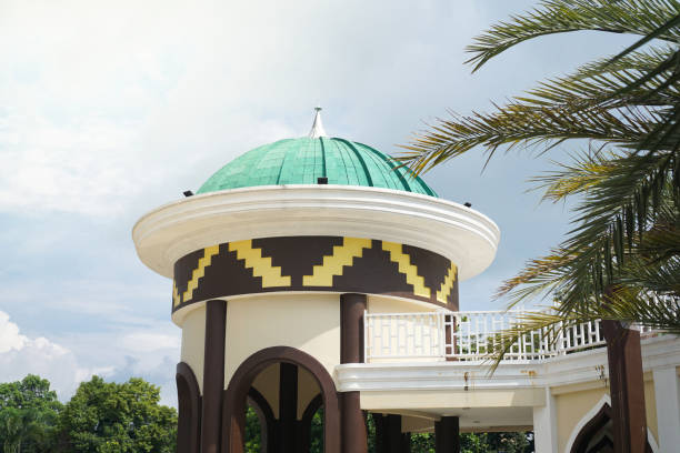 istock Mosque with green dome and detailed patterns, set amidst vibrant palm trees and clear blue sky 2164818853