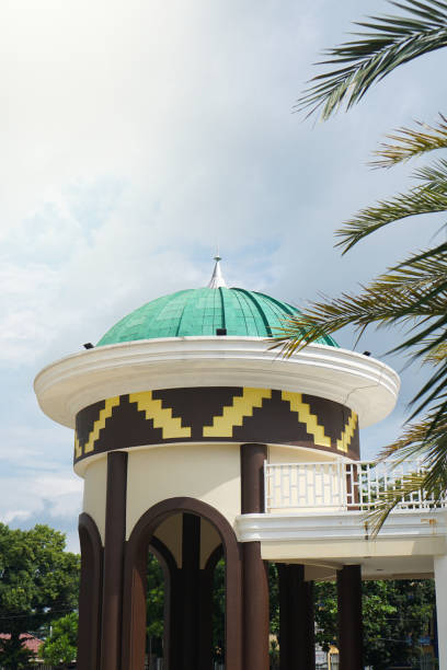 istock Mosque with green dome and detailed patterns, set amidst vibrant palm trees and clear blue sky 2164818854