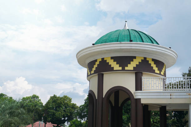 istock Mosque with green dome and detailed patterns, set amidst vibrant palm trees and clear blue sky 2164819061