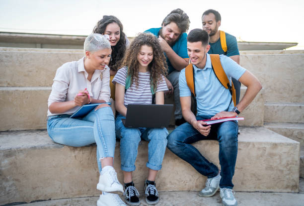 istock Group of students gathers around a laptop 2164820313