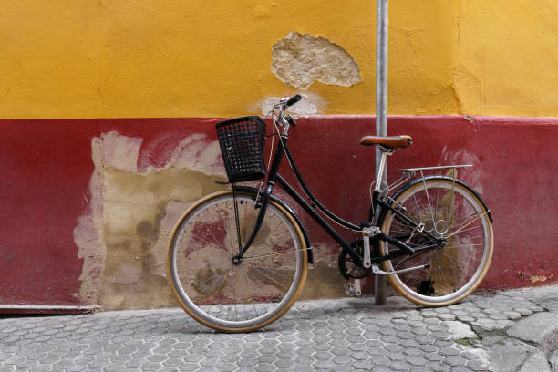 istock A black bicycle parked against a yellow and red wall in Spain 2164820352