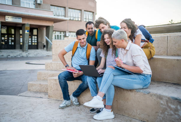 istock Group of students gathers around a laptop 2164820603