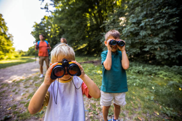 istock Two little boys looking through binoculars. Hiking and exploring the nature. 2164821503