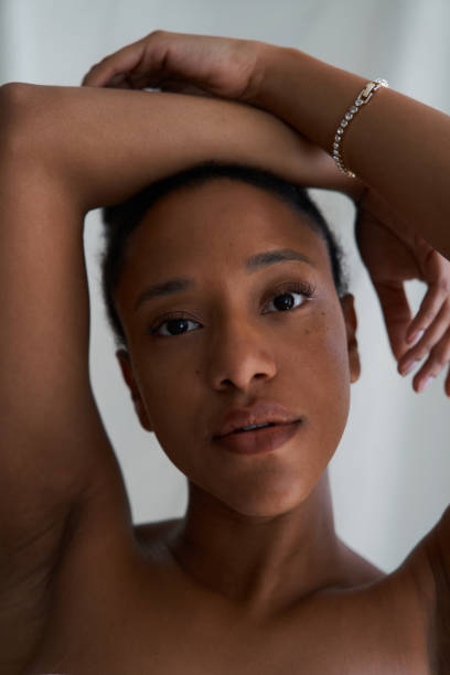 istock Young black woman posing with arms raised above head 2164824742