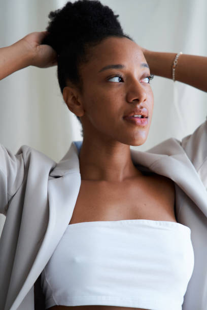 Young black woman tying her hair up while getting ready for work