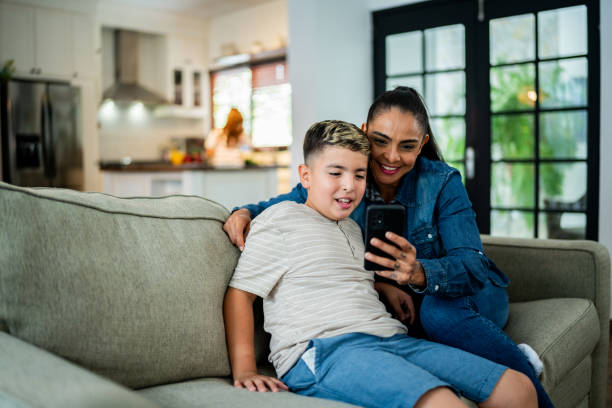 istock Mother and son using mobile phone at home 2164825162
