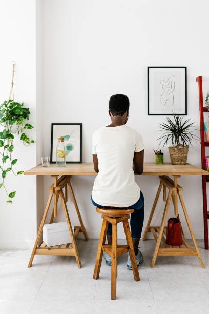 istock Creative young african woman working on laptop at home studio office 2164825503