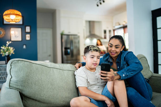 istock Mother and son using mobile phone at home 2164826247