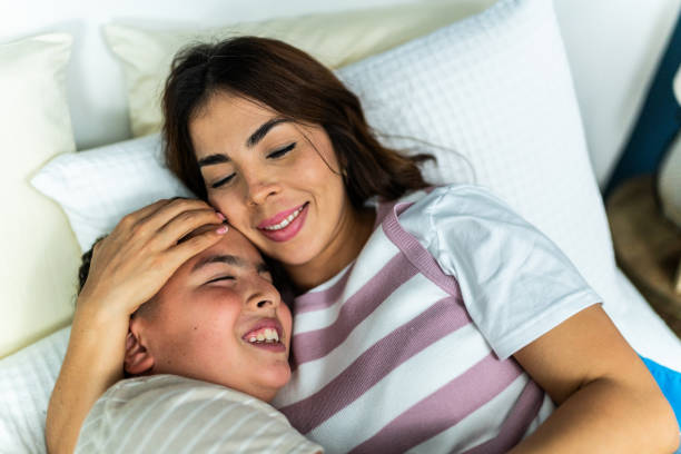 istock Mother and son lying down on bed at home 2164826407