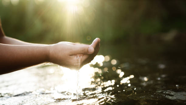 istock A female hand touching the river water 2164826927