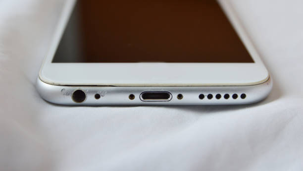Bottom view of used smart phone in white linen background