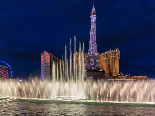 Las Vegas, Nevada, USA - January 10, 2016: Las Vegas strip from during the night and a view at the Paris Hotel and Casino with a replica of the Eiffel Tower. In front a fountain show at the Bellagio lake.