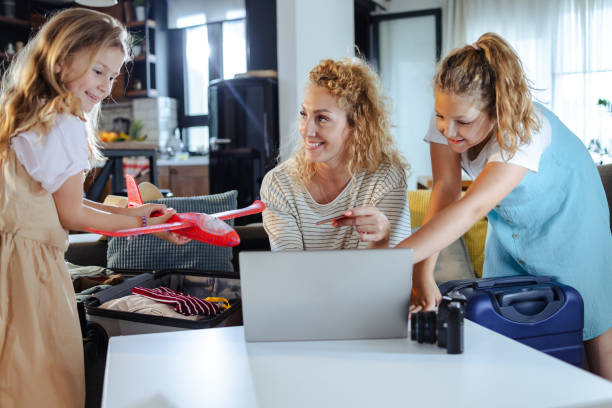 istock Mother using a credit card to book a trip online with her daughters by her side 2164834041