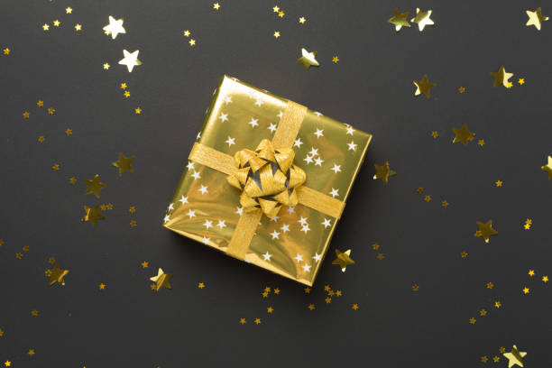 istock Golden gift boxes and confetti on color background, top view 2164834777