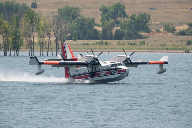 Flying on the surface of the water past paddlers on the Chatfield State Park, a fire fighting CL-415 scooper tanker number 263 vacuums up to 1600 gallons of water for extinguishing flames on the nearby Quarry Fire in Deer Creek Canyon Littleton, Colorado on July 31, 2024.