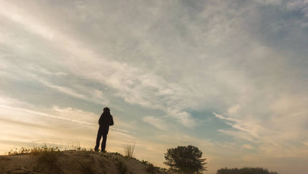 istock Man in the dunes with sunset 2164841133