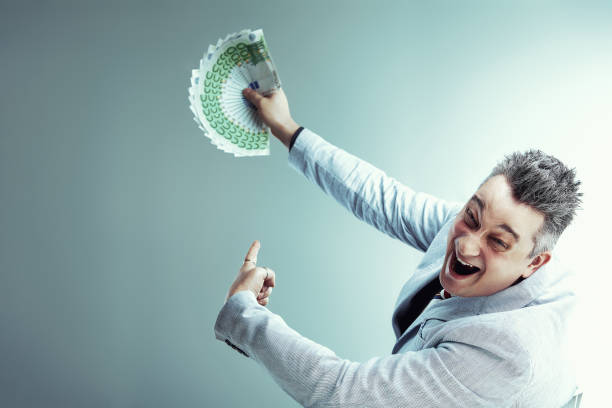 istock Sly salesman holding euro banknotes and pointing 2164843990