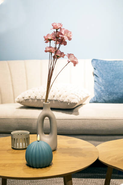 vase with decorative flowers on a round table in the interior. Modern interior