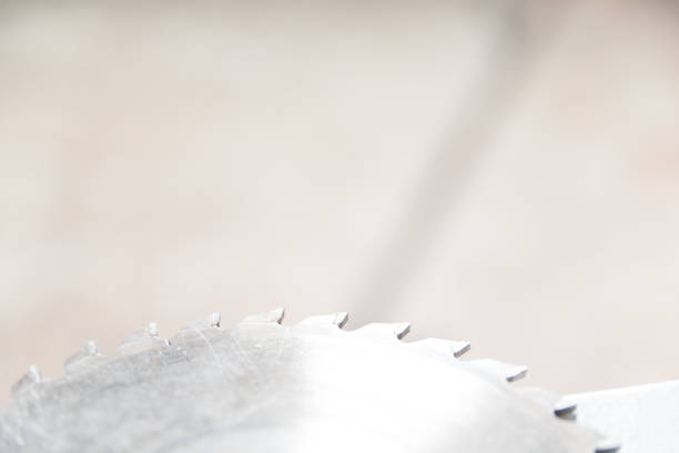 Different old partially rusty circular steel saw blades for cutting wood on a stationary electric saw machine are hanging on a wall