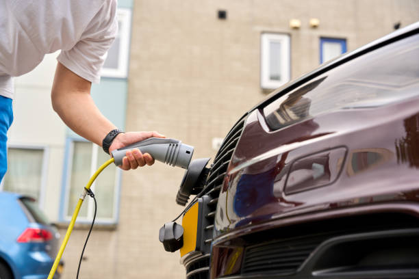 istock The young man is charging his electric car. 2164846475