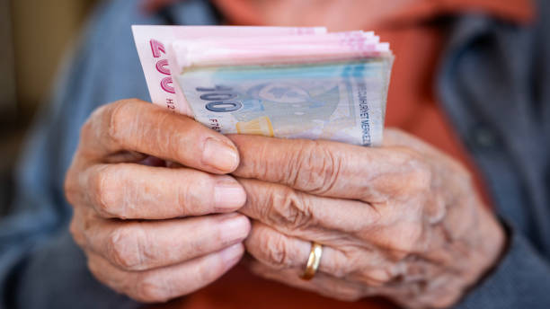 istock Old woman counting Turkish lira banknotes 2164856354