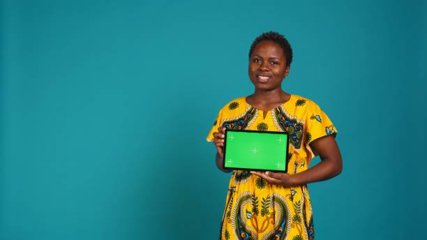 istock Cheerful positive girl presenting a green screen on her tablet 2164861258