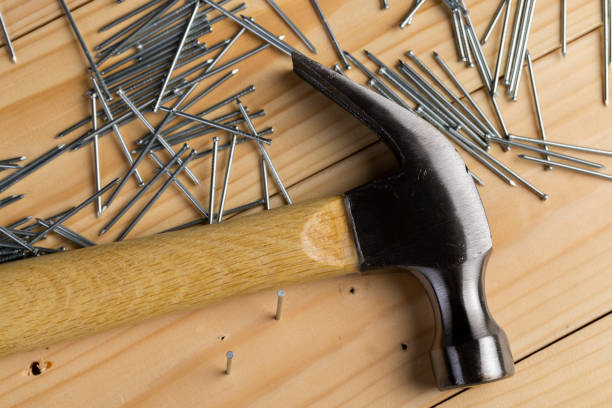 istock nails with small caps and an iron hammer on boards 2164862568