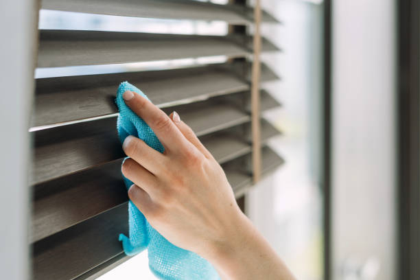 istock Person cleans a window blinds using a blue cloth 2164864153