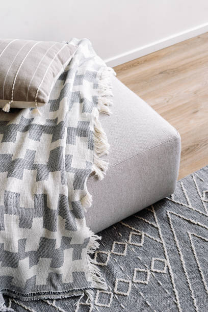 istock Textile throw blanket on a gray ottoman, close up view 2164864167