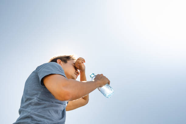 istock Man drinking water feeling hot and exhausted from the summer heat. 2164866895
