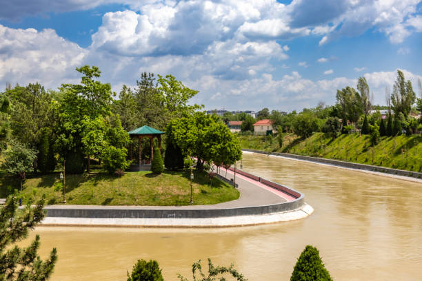 Drone aerial view of a large cargo tanker moving along a river, carrying containers or bulk goods, highlighting water-based transportation.