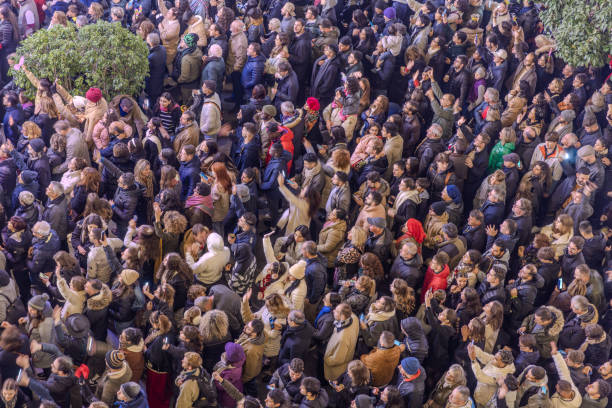 Seville, Spain - January 1, 2024:  A big crowd of people at Plaza de San Francisco anxiously waiting for the new year, with about 20 minutes to go.  HDR encoded.
