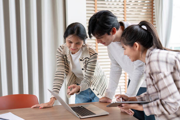 istock Group of Diverse Student Collaboration on a Project Using a Laptop and Tablet in a Modern Classroom Setting 2164885218