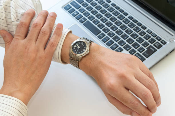 istock Man looking at his watch while working in the office 2164891731