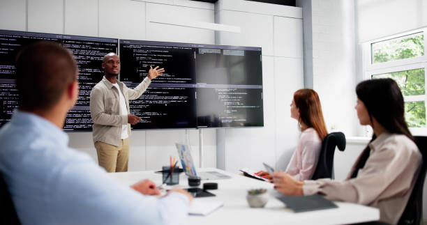 istock Programmer Team Meeting With TV Screen In Office 2164892081
