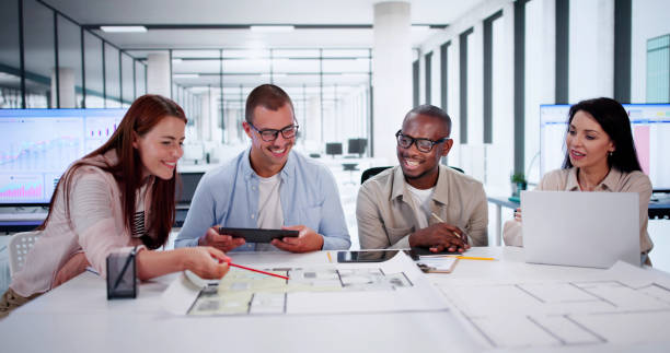 istock Designer Group At Desk Discussing Custom House 2164892125