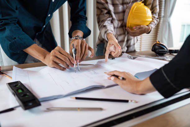 Architect collaboration on Blueprint Design at Construction Site with Tools and Safety Gear