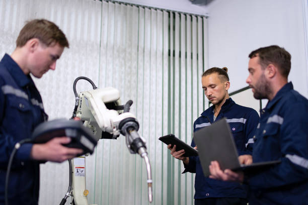 istock Group of Engineers are working at robotics workshop. 2164895820