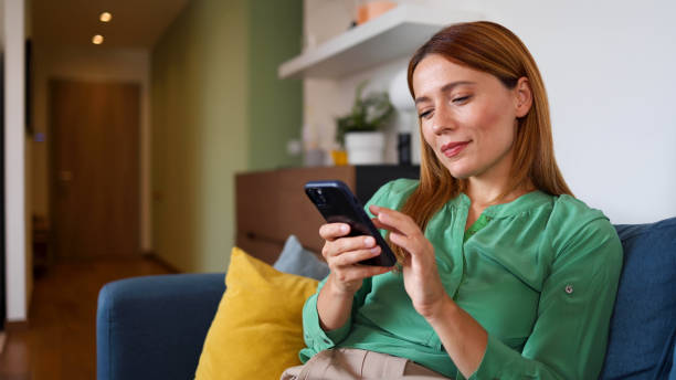 istock Woman enjoying home and texting on smartphone 2164897403