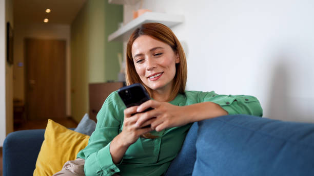 istock Woman enjoying home and texting on smartphone 2164897449