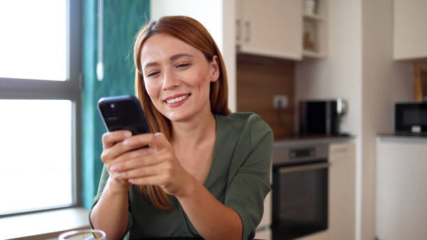 istock Happy woman having fun on her smartphone 2164897600
